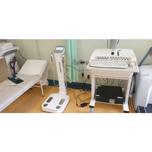 Analizator składu ciała ACCUNIQ BC380 opcja white ustawiony obok stanowiska diagnostycznego.