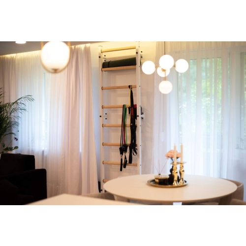 Drabinka BenchK 700W zamontowana w jasnym wnętrzu, z akcesoriami treningowymi.