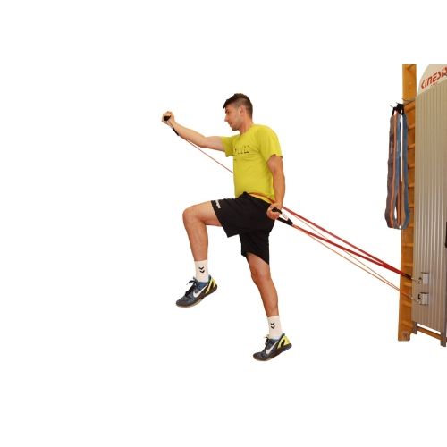 Ćwiczenie z wykorzystaniem kolumny Easy Core i gum oporowych, mężczyzna wykonujący ruch oporowy.