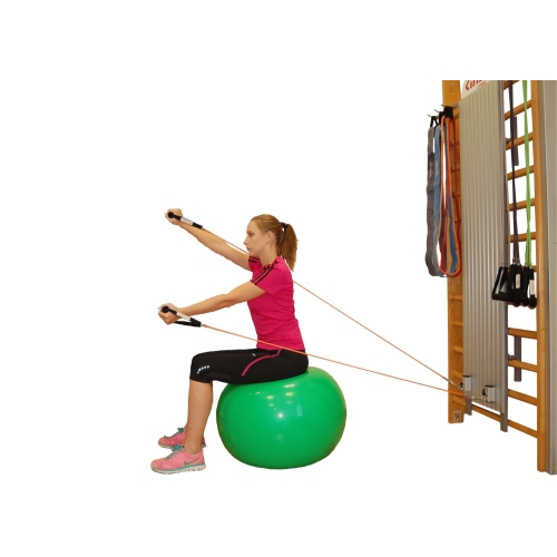 Ćwiczenie siedzące z użyciem kolumny Easy Core i taśm oporowych, kobieta w pozycji na piłce.