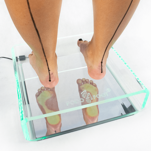 Podoskop diagnostyczny z podświetlaną szklaną platformą, prezentujący odbicie stóp podczas badania.