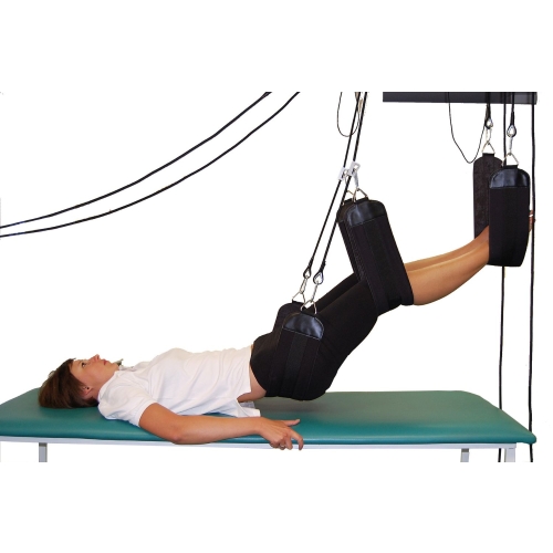 Ćwiczenia w podwieszeniu nóg w systemie Sling Therapy Kinesis na stole rehabilitacyjnym.