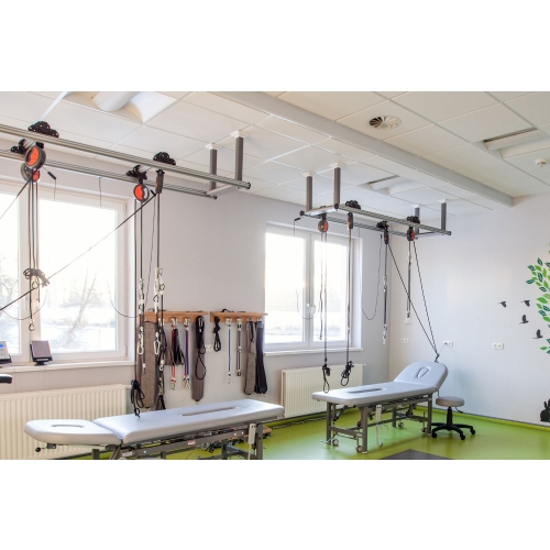 Sala rehabilitacyjna wyposażona w system Sling Therapy Kinesis z torami sufitowymi i akcesoriami.