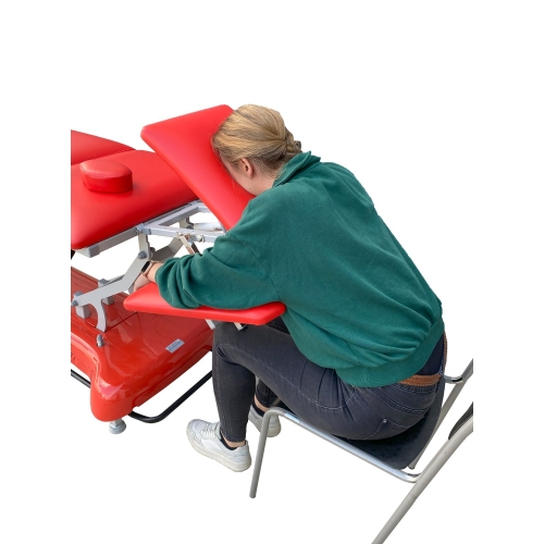 Osoba korzystająca z zagłówka KINESIS podczas masażu w pozycji siedzącej.